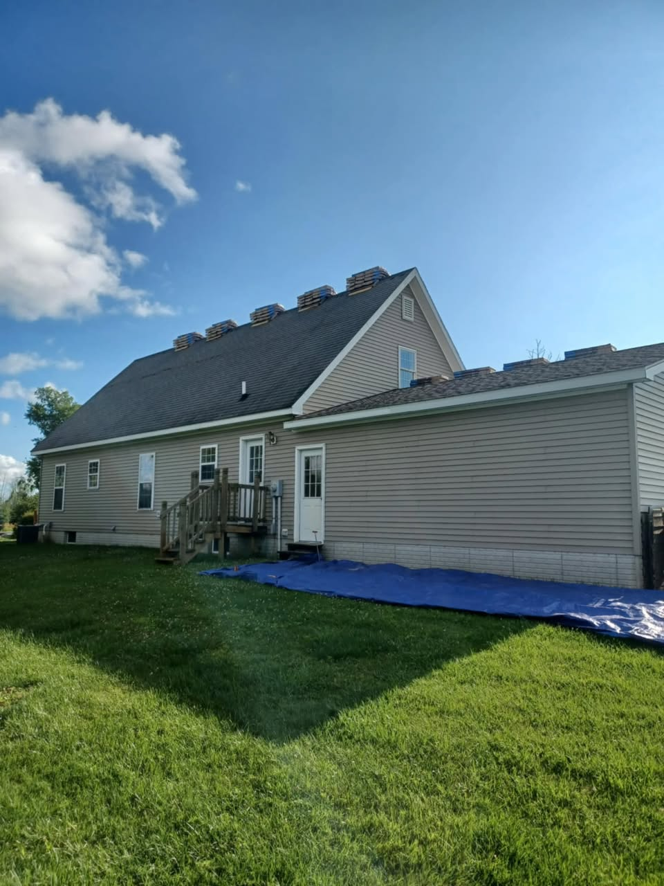 New shingles being staged on roof during Michigan roof replacement
